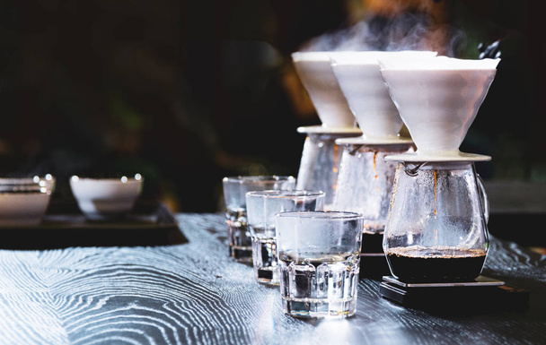 Бариста варит кофе, готовит кофе с помощью химикатов, химикаты капают горячим свежим кофе
 - Фото, изображение