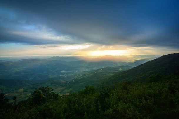 Táj napfelkeltét a hegyi hill sárga ég és emelkedő napsütés a reggel és a hegység a háttérben - Fotó, kép