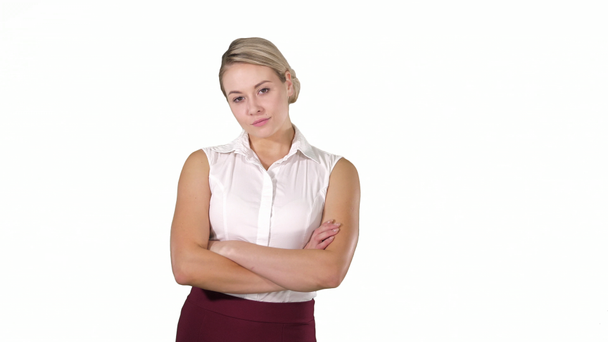 Medium shot. Beautiful confident young businesswoman standing with hands folded on white background. Professional shot in 4K resolution. 005. You can use it e.g. in your commercial video, business - Materiaali, video