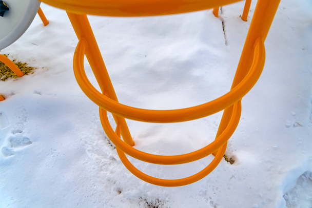 Escalera naranja brillante contra nieve de mierda polvorienta
 - Foto, Imagen