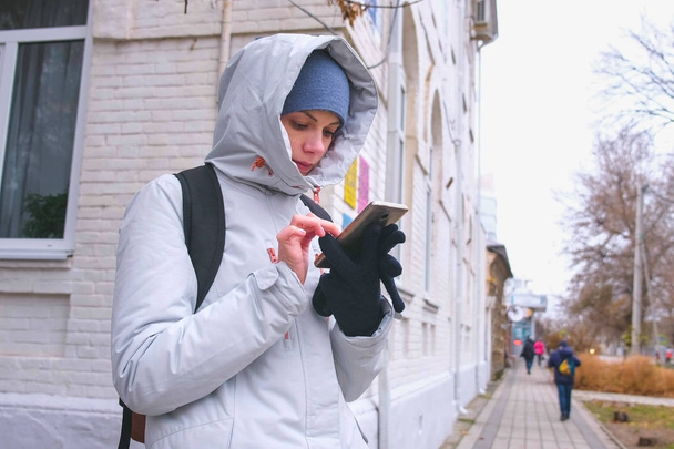 Woman got lost in the city and looking for a route using the Navigator in the mobile phone. - Foto, Bild