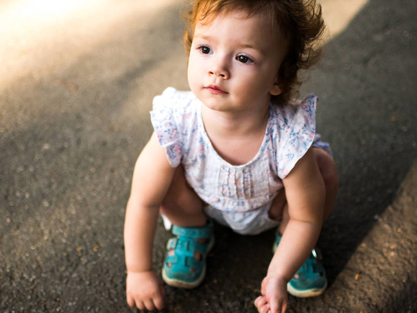 Retrato de una hermosa niña pequeña. Imagen al aire libre de un hermoso niño rizado
 - Foto, imagen