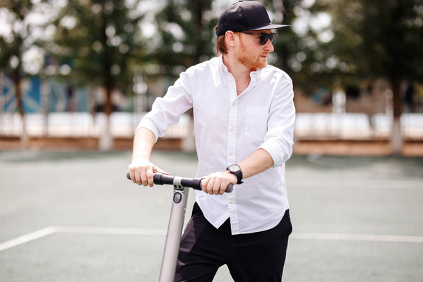 Photo of modern man with electric scooter at the street - Photo, Image