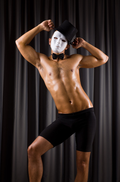 gespierde acteur met masker tegen gordijn - Foto, afbeelding