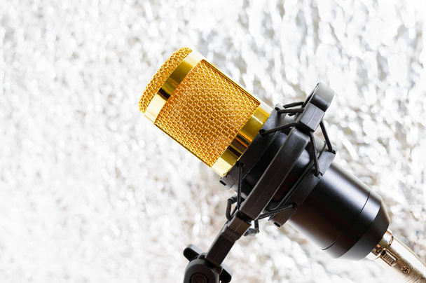 Krásný zlatý mikrofon na světlo rozmazané pozadí, zblízka, bokeh. - Fotografie, Obrázek