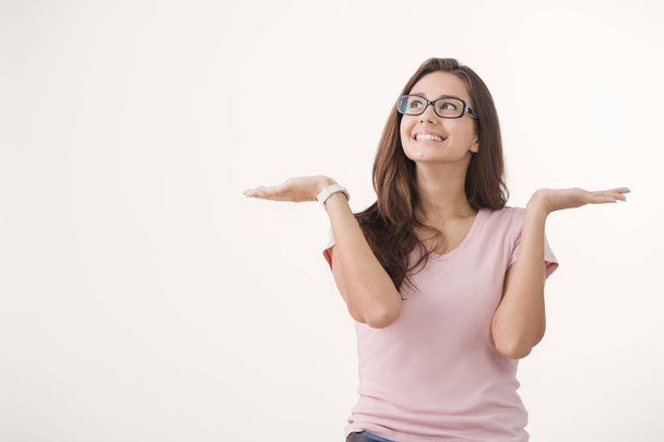Nuoren iloisen ruskeahiuksisen naisen muotokuva silmälasit valkoista taustaa vasten
 - Valokuva, kuva