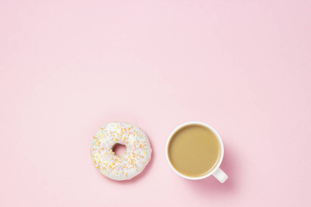 Beker met koffie of thee. Verse zoete smakelijke donut op een roze achtergrond. Concept van de bakkerij, vers gebak, heerlijk ontbijt, fastfood, koffie shop. Plat lag, top uitzicht - Foto, afbeelding