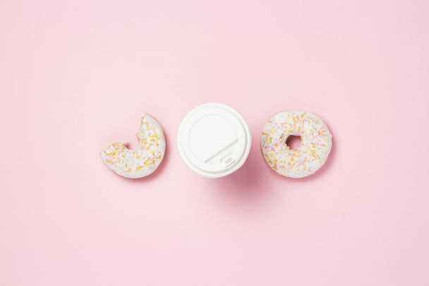 Paper cup with a plastic lid, coffee or tea, Fresh tasty sweet donut on a pink background. Fast food concept, bakery, breakfast, sweets, coffee shop, take-away food. copy space. Flat lay, top view - Foto, afbeelding