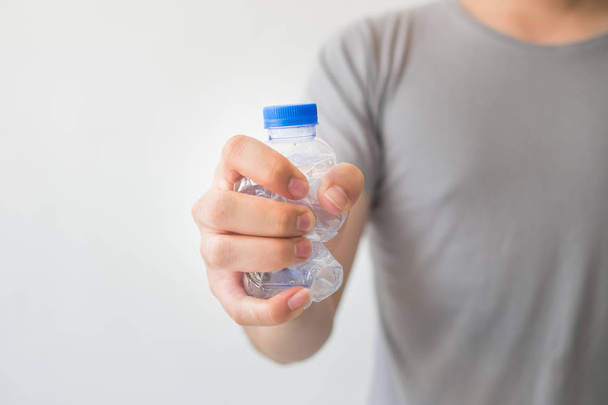 Hand holding a recyclable plastic bottles on white background. - 写真・画像