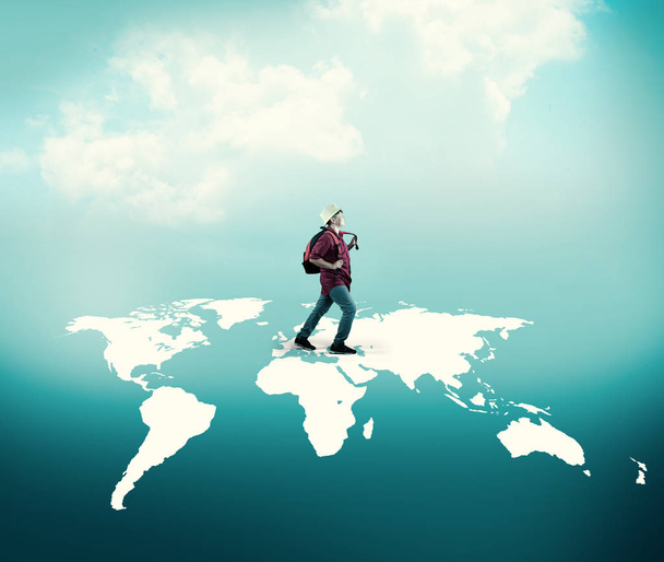 Excited traveler walks across world map. - Photo, Image