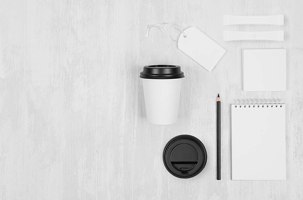 Coffee shop template for branding identity - white paper cup, black cap, blank notebook, label, card on white wood board, copy space, top view. - 写真・画像