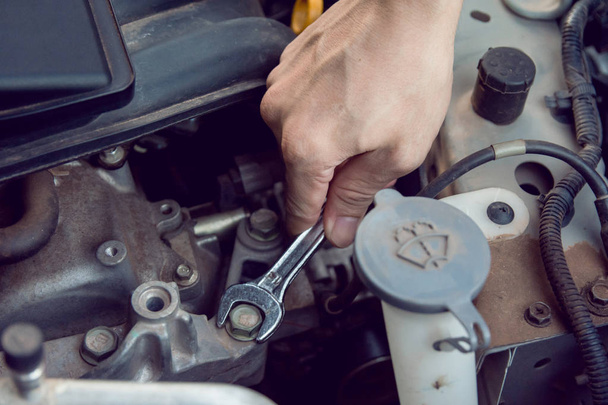 Automechaniker arbeitet mit Schraubenschlüssel in der Garage. Reparaturservice. - Foto, Bild