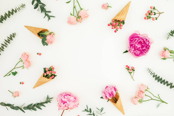 Floral frame with pink peonies, roses petals, eucalyptus and waffle cones on white background. Flat lay, top view - Photo, Image