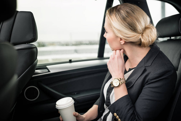 Mujer de negocios sentada en el coche mirando por la ventana del coche
 - Foto, imagen