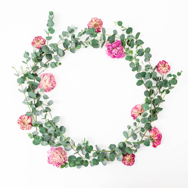 Floral frame with pink roses flowers and eucalyptus branches on white background. Flat lay, top view - Foto, immagini