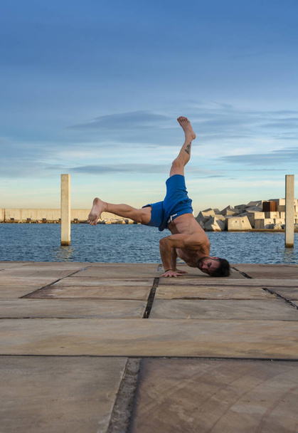Man performing advanced yoga exercises and stretching to keep the body healthy - Φωτογραφία, εικόνα