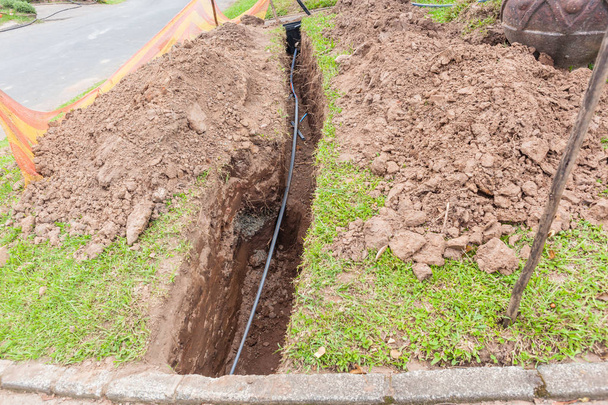 De nouveaux câbles à fibre optique à vitesse rapide sur Internet ont été installés sous terre dans des tranchées le long de la route devant les résidences
 . - Photo, image