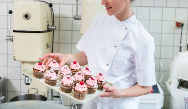 Baker women in pastry bakery working on muffins - Фото, зображення