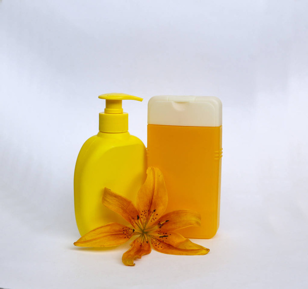 cosmetic set for skin care on a white background with flowers lilies.  composition for Spa, bath, sauna, shower.  shower  soap and shower gel  with yellow lily for gentle cleansing of  skin - Photo, Image