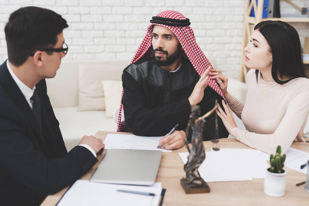 Lawyer in suit in office with arab husband and wife. Man is asking questions about divorce. - 写真・画像