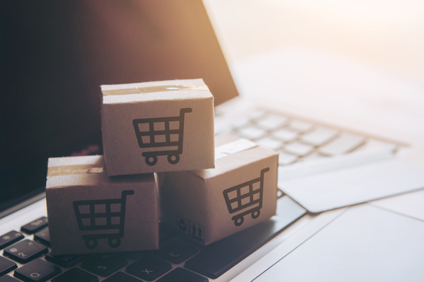 Shopping online concept - Shopping service on The online web. with payment by credit card and offers home delivery. parcel or Paper cartons with a shopping cart logo on a laptop keyboar - Fotoğraf, Görsel