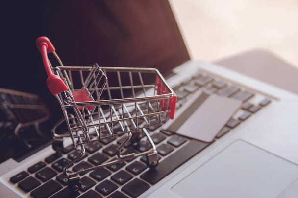 Online-Shopping-Konzept - Shopping-Service im Internet. bietet Lieferung nach Hause. Leerer Einkaufswagen auf einer Laptop-Tastatur - Foto, Bild