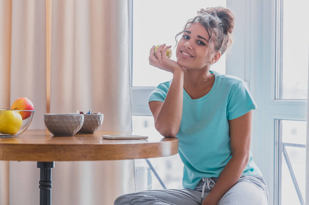 Beautiful, calm young woman with a cup of coffee, relaxing hot drink, happy lady holding a cup. Pretty brunette. The girl is sleepy. Food and drink. - Photo, Image
