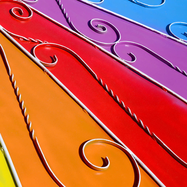 Textura metálica de una pieza de pared de color con un patrón forjado. Colores del arco iris
 - Foto, Imagen