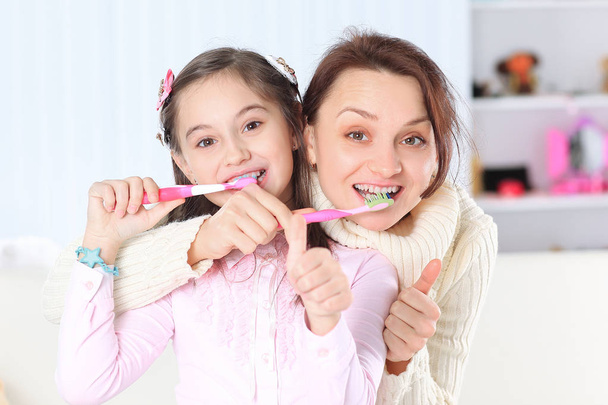 mom and daughter brushing their teeth.photo with copy space - Photo, Image