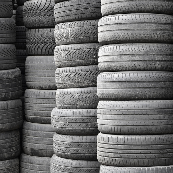 Vanhat käytetyt renkaat pinottu korkea paaluilla toissijainen auton osat shop autotalli lähikuva
 - Valokuva, kuva