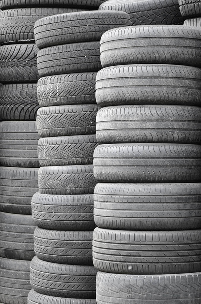 Old used tires stacked with high piles in secondary car parts shop garage close up - Photo, Image