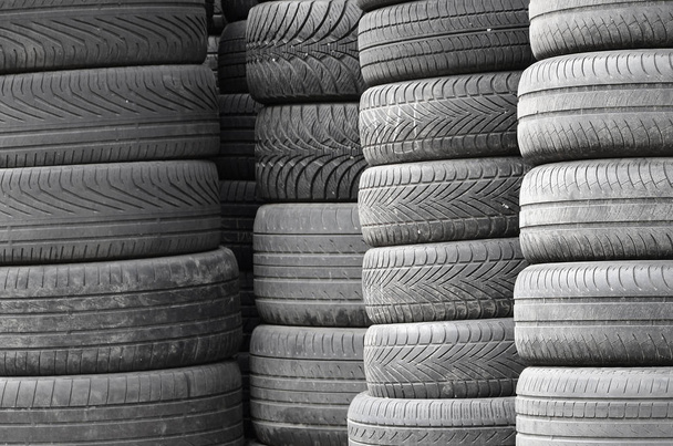Vanhat käytetyt renkaat pinottu korkea paaluilla toissijainen auton osat shop autotalli lähikuva
 - Valokuva, kuva