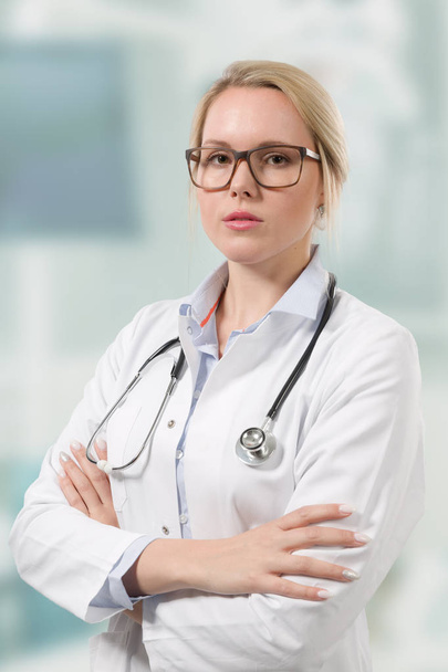 female doctor with stethoscope looks seriously - Photo, image