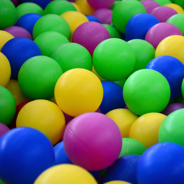 Цветные пластиковые шарики в бассейне игровой комнаты. Бассейн для развлечения и прыжки в цветных пластиковых шариках
 - Фото, изображение