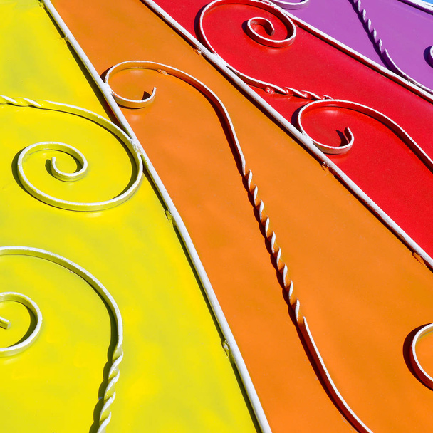 Metallstruktur eines farbigen Wandstücks mit geschmiedetem Muster. Regenbogenfarben - Foto, Bild