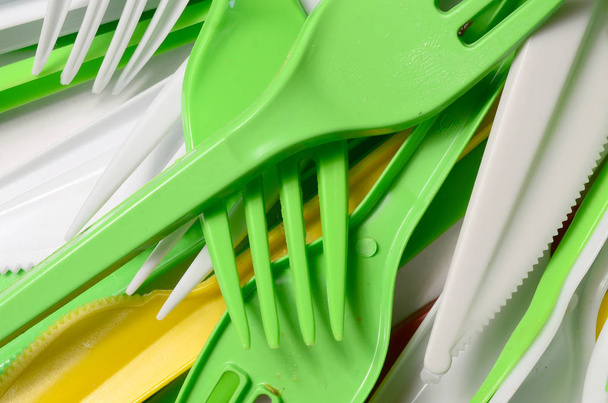 Pile of bright yellow, green and white used plastic kitchenware appliances. Ecological problem. Plastic pollution - Photo, Image