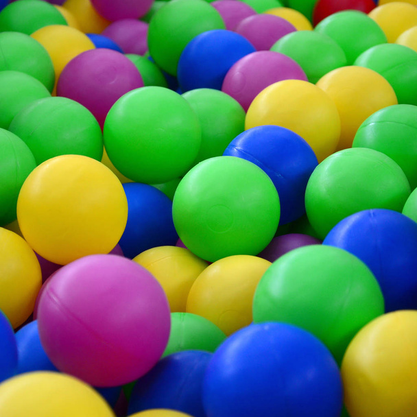 Kolorowe kulki z tworzyw sztucznych w basenie z pokoju gier. Basen dla zabawy i skoki w kolorowe kulki z tworzyw sztucznych - Zdjęcie, obraz