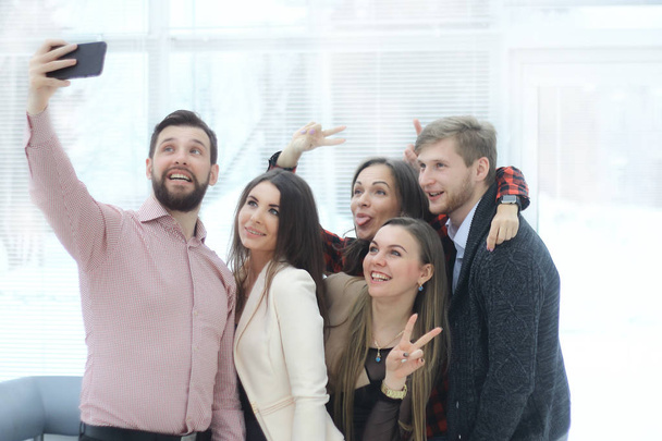 creatieve bedrijfsgroep neemt selfies in een modern kantoor - Foto, afbeelding