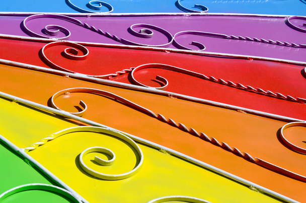Металлическая текстура куска цветной стены с выкованным рисунком. Радужные цвета
 - Фото, изображение