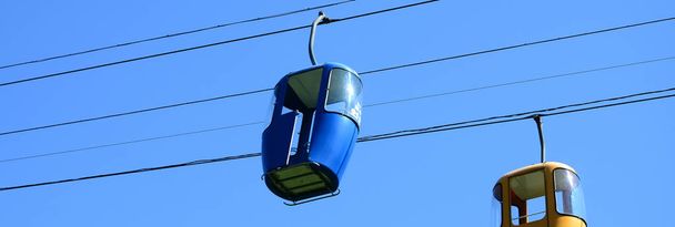 Pasażer niebieskiego i żółtego kabla sposób kabiny w błękitne niebo - Zdjęcie, obraz