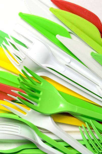 Σωρός από φωτεινό κίτρινο, πράσινο και άσπρο πλαστικό μαγειρικά σκεύη μόνο χρησιμοποιούν συσκευές σε λευκό φόντο - Φωτογραφία, εικόνα