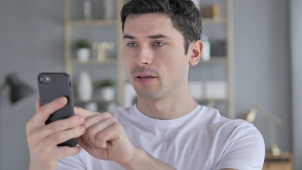 Young Man in Shock while Using Smartphone, Wondering - Materiał filmowy, wideo