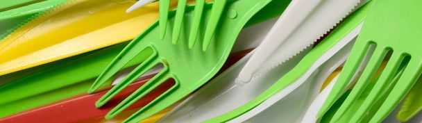 Купка яскраво-жовтих, зелених і білих використовувала пластикові кухонні прилади. Екологічна проблема. Пластикове забруднення
 - Фото, зображення