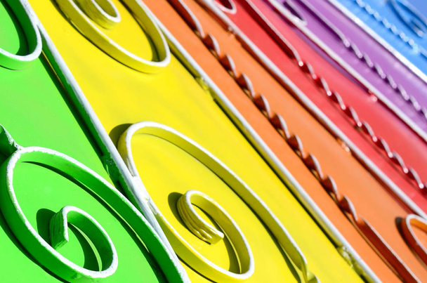 Metallstruktur eines farbigen Wandstücks mit geschmiedetem Muster. Regenbogenfarben - Foto, Bild