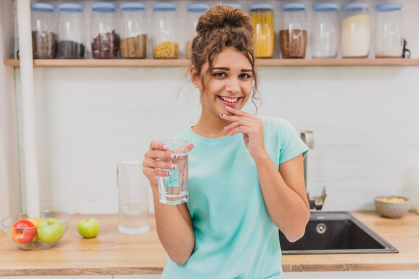 Hermosa, hermosa, joven mujer sosteniendo un vaso de agua dulce y sonriendo
 - Foto, imagen