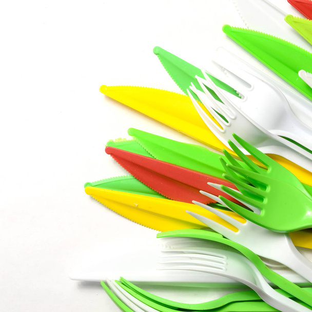 Montón de amarillo brillante, verde y blanco utensilios de cocina de plástico de un solo uso electrodomésticos sobre fondo blanco
 - Foto, Imagen