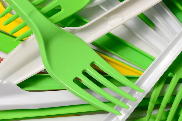 Pile of bright yellow, green and white used plastic kitchenware appliances. Ecological problem. Plastic pollution - Foto, imagen