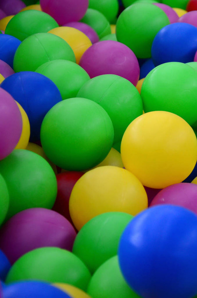 Colored plastic balls in pool of game room. Swimming pool for fun and jumping in colored plastic balls - Photo, Image