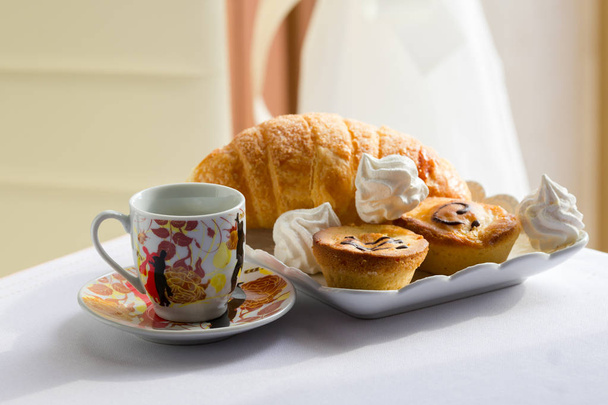 Croissant y una taza de delicioso café, sur italiano tradicional desayuno dulce, sobre un fondo brillante, Apulia, Salento
 - Foto, imagen