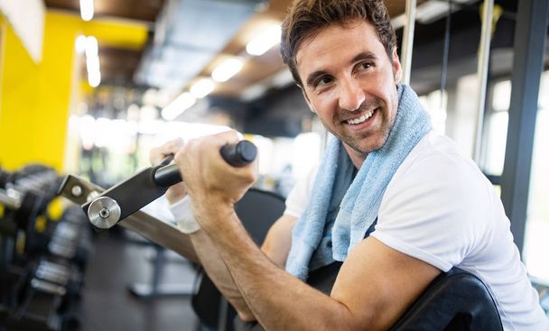 Lifestyle portrait of handsome muscular man with towel after the training in the sport gym - Photo, Image